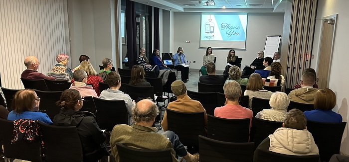 a photo of a group of people sitting facing a projector screen in a hotel function room